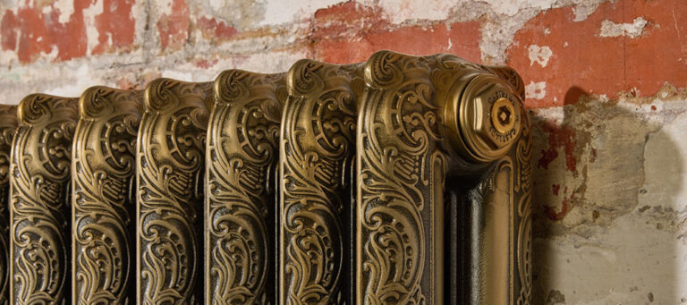 Ornate Rococo cast iron radiator in Aged gold finish.